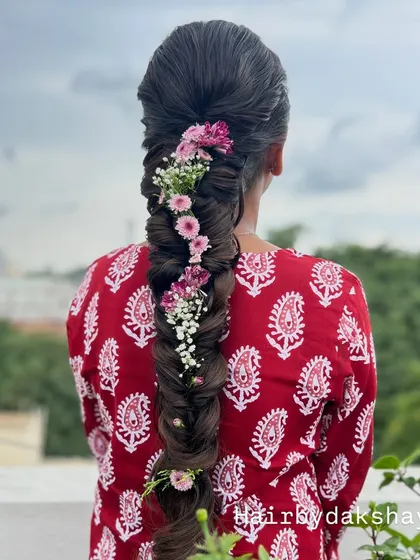 A clear, high-quality shot of the fishtail braid with fresh flowers, showcasing the healthy shine of the hair.