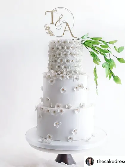 An elegant wedding cake featuring our custom gold monogram topper. It's a timeless piece that adds a personal touch to a couple's special day.