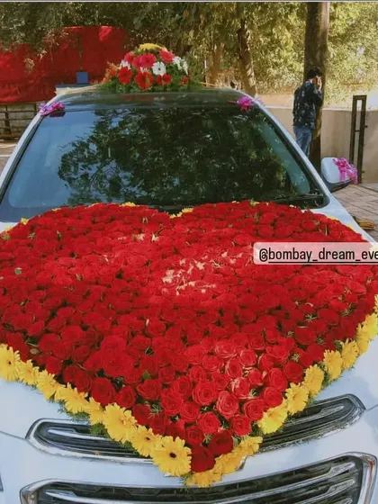 A grand floral statement on wheels. This car is decorated with a giant heart made of red and yellow flowers on the hood, perfect for weddings or a very special romantic gesture.