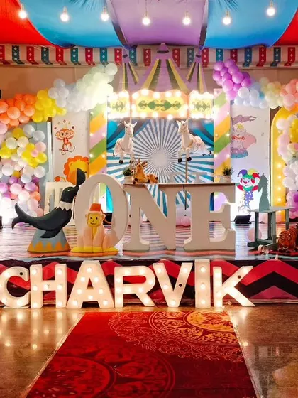 Step right up to the greatest party in town! We created this spectacular carnival theme for Charvik's first birthday, featuring a grand stage with circus tent draping, colourful balloon arrangements, and custom props like the light-up name and marquee number.