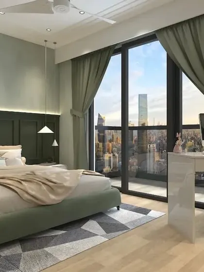 A bedroom with a soothing sage green color palette, featuring wall paneling behind the bed and a minimalist study desk with a city view.