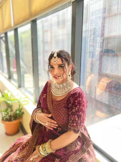 A full-length view of the royal bride, showcasing the harmony between the makeup, velvet lehenga, and heavy jewelry. My course covers how to style a complete and cohesive bridal look.