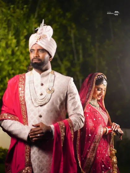 A stylish portrait of the couple. The groom looks forward with a regal expression, while the bride looks down demurely, creating a classic and poised composition.