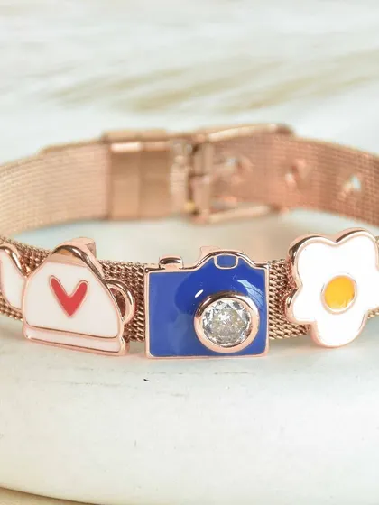 A cute and quirky watch belt in rose gold. This piece is adorned with a teapot, a camera, and a fried egg charm for a truly unique and personal accessory.