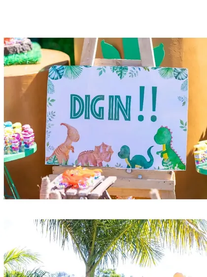 A 'DIG IN' sign at the dinosaur party's candy and dessert table, inviting guests to enjoy the treats.