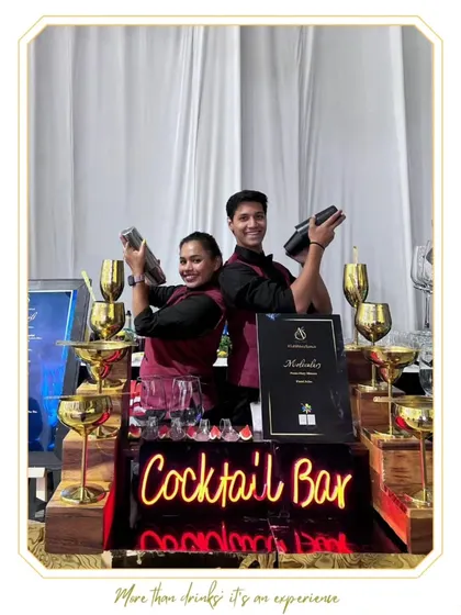 Two of our bartenders, a man and a woman, shaking cocktails in unison. This shot highlights the synchronized teamwork and skill of our diverse staff.