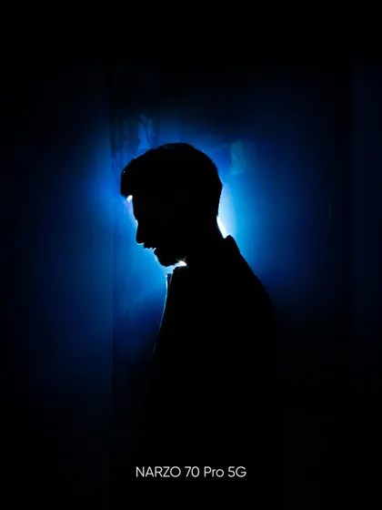 A silhouette portrait with a strong blue backlight. This image plays with shadow and light to create a dramatic and anonymous profile.