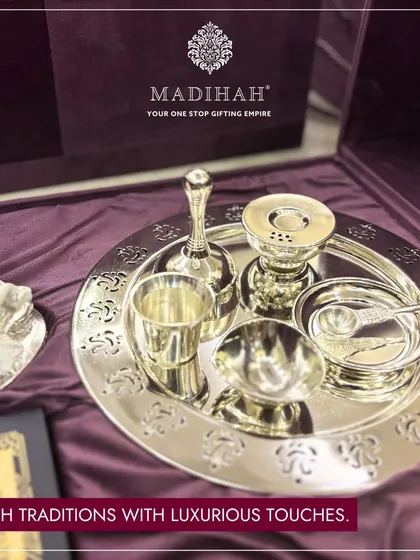Cherish traditions with luxurious touches. A close-up of the silver-plated pooja thali, complete with a bell, diya, and other essential items, all showcasing intricate craftsmanship.