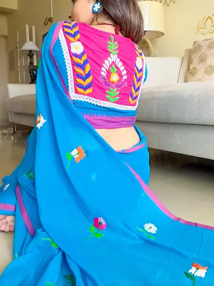 A close-up of the stunning hand-embroidered blouse back, paired with the blue mul saree. The craftsmanship is just incredible.