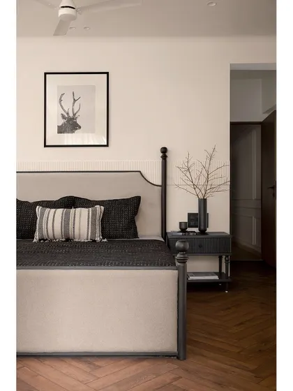 For this tranquil master bedroom, we designed a sophisticated half-poster bed as the centerpiece. Paired with herringbone flooring and a custom wardrobe with curved details, the room is a haven of understated elegance and modern comfort.