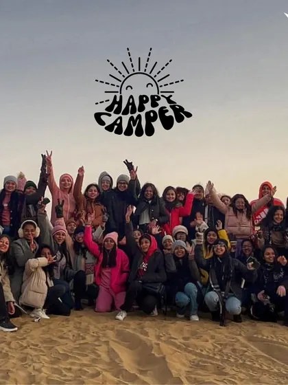 A large group of happy campers posing in the Jaisalmer desert. This is what our community looks like: full of energy and ready for adventure.