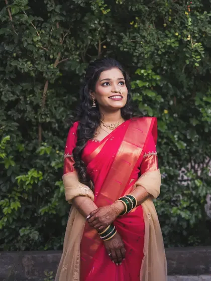 A stunning outdoor portrait of the bride in a vibrant red saree, her smile as bright as her attire.