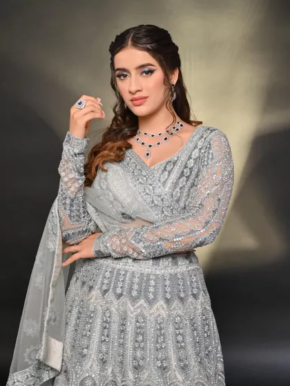 Another look at the elegant grey lehenga, paired with a sapphire necklace to add a pop of color. It's a versatile piece that can be styled in many ways.