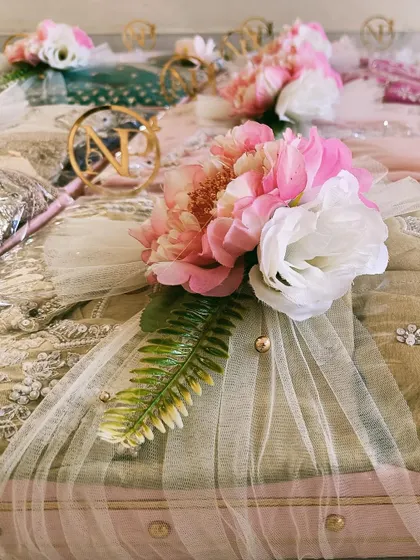A close-up of the delicate tulle and floral wrapping on a trousseau gift. The small details, like the gold-beaded accents, make our packing truly special.
