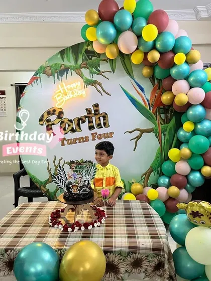 A personalized jungle-themed party for Parth's fourth birthday. The backdrop is a custom print, complemented by a colorful balloon garland.