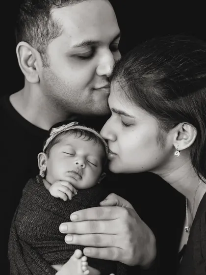 There is a timeless power in black and white photography. It strips away distractions and focuses on the pure emotion of the moment, like the tender, quiet love between new parents and their baby. These are the portraits that become family heirlooms.