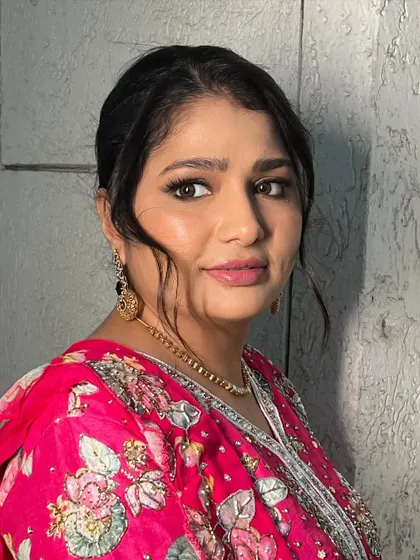 This portrait showcases the complete look, with soft face-framing hair and makeup that highlights her beautiful smile.
