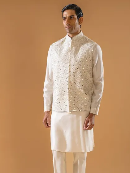 This ivory Jawahar jacket is adorned with intricate threadwork and shimmering mirror details. It is the epitome of grace for the spring season, perfect for adding a touch of sparkle to your ensemble.