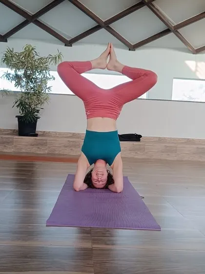A guest demonstrates an advanced headstand variation, showcasing the strength and balance that can be achieved through consistent yoga practice. Our instructors provide guidance for all levels, from beginner to advanced.