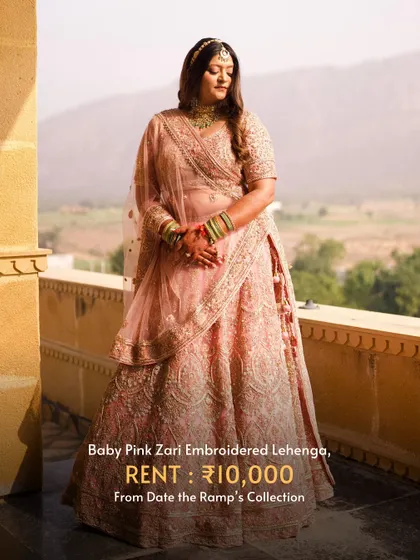 A beautiful baby pink zari embroidered lehenga, shot against a stunning backdrop.