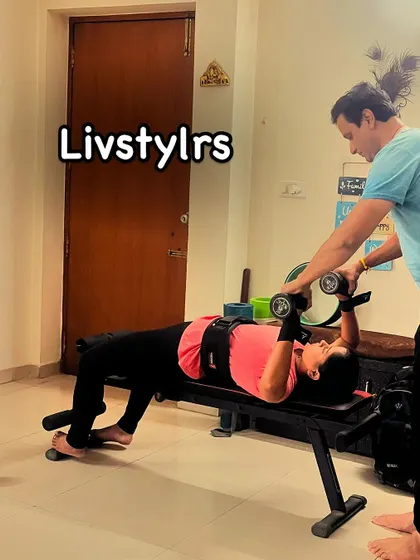 I'm assisting a client with a dumbbell bench press, ensuring she maintains safe and effective form to build upper body strength.