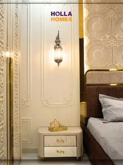 A detail shot of the classic wall mouldings and ornate bedside lamp, which contribute to the authentic Parisian feel of the bedroom.