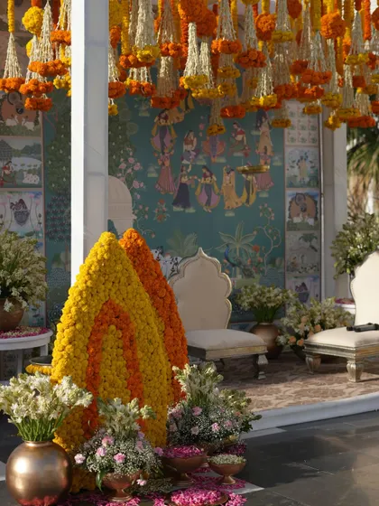 The combination of traditional marigold decorations with the elegant white architecture of the venue created a beautiful fusion of styles.