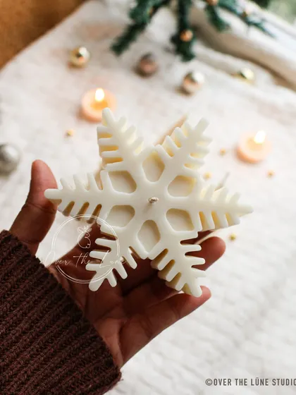 A large, intricate snowflake candle from my Christmas collection. It's a beautiful centerpiece for a winter wonderland theme.