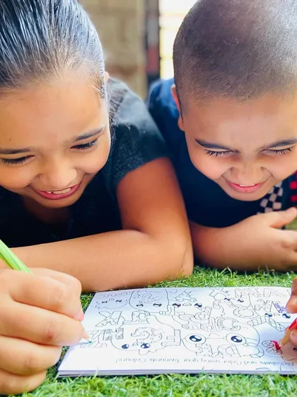 Teamwork makes the dream work! Siblings sharing a fun moment while coloring together.