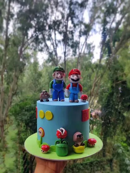 A full view of my Super Mario cake against a natural backdrop. The handmade fondant characters really stand out, ready for a birthday adventure.