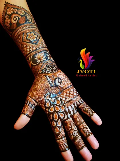 A simple yet beautiful bridal henna design. This piece highlights a peacock on the palm with its feathers flowing down the wrist, surrounded by floral and geometric patterns.