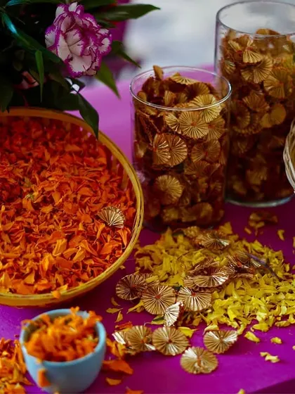 A close-up of the flower station, with bowls of fresh marigold petals and other floral elements, ready for the guests to use in the celebrations.