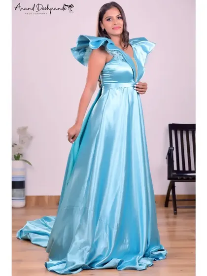 A stunning sky-blue satin gown with dramatic ruffled shoulders and a plunging neckline. This rental gown comes with a long trail for an extra touch of glamour.