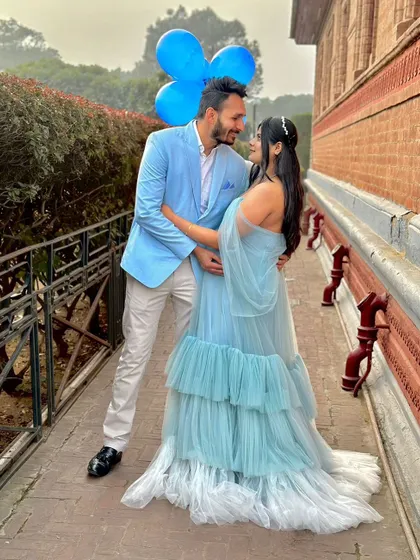 An outdoor shot showing how our Winter gown can be styled for a fun, coordinated couple's look. The blue tones are perfect for a "it's a boy" theme.