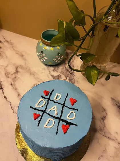 Celebrate Dad with a cake that's just for him. This Father's Day cake features a fun tic-tac-toe design, showing him he's a winner. Whether it's a simple mango cake or a rich chocolate one, it's a sweet way to show you care.