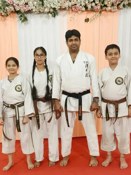 Senior students with their brown belts, standing with their Sensei at the Rejoice International School event. They are role models for the younger students.
