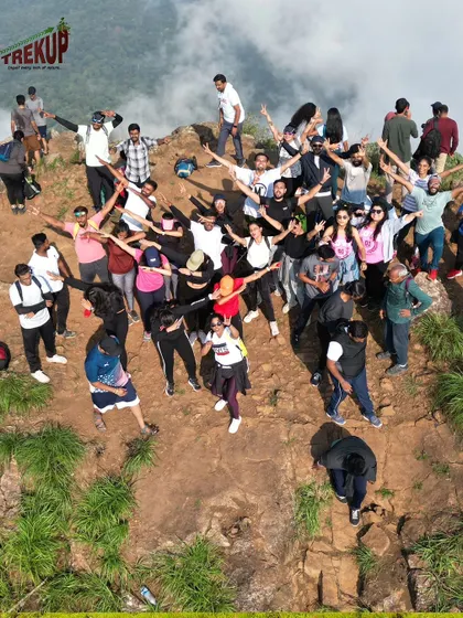 A drone's eye view of our trekking group celebrating on a cliff. The sense of community and shared achievement is what makes these trips special.