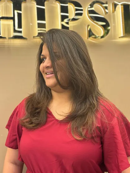 A three-quarter view of a client's new hair color. The soft layers and natural-looking highlights create a beautiful, understated style.