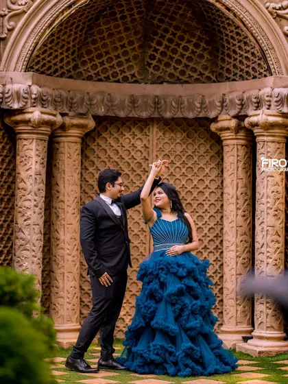A classic dancing pose in front of a grand, carved doorway. The bride's textured blue gown adds a touch of modern elegance to this timeless romantic portrait.