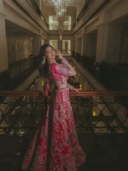 A stunning solo portrait of the bride in her intricate lehenga, captured in a beautifully lit hotel corridor.