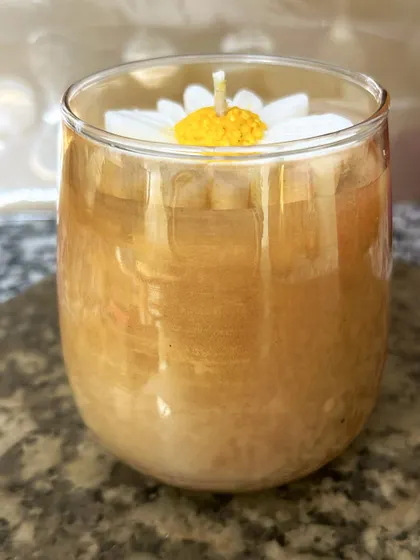 The unlit daisy candle in a golden glass jar. It's a beautiful decor piece even when not in use.