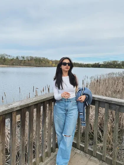 No bad vibes at Heart Lake, Ontario, posing on a wooden platform in a casual spring outfit.