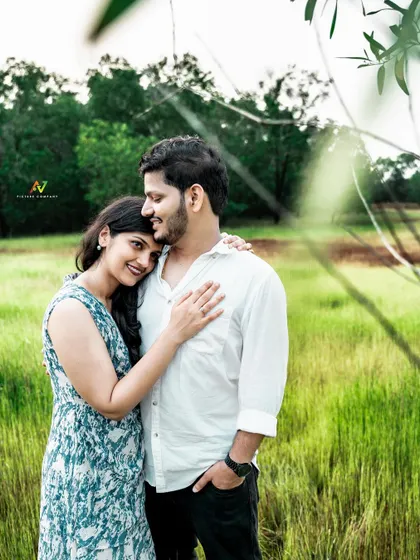 An intimate embrace in a field, with the bride resting her head on her partner's shoulder.