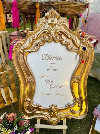 We believe in thoughtful details that enhance guest comfort. This ornate, gold-framed sign kindly offers blankets for guests to use at a chilly outdoor wedding.