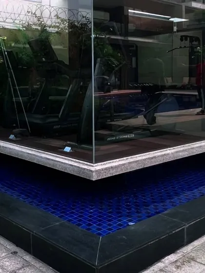 A unique water feature wraps around the corner of a glass-walled gym. This design brings the calming element of water right up to the building, creating a beautiful view from inside.