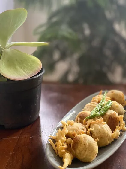 A plate of hot, crispy Mini Vadas, a perfect savory snack, especially during the monsoon. I serve them with fried green chilies, just the way they are enjoyed back home.