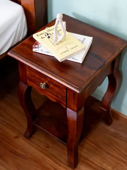 Another view of the elegant bedside table, showcasing its graceful curves and the beautiful grain of the Sheesham wood.