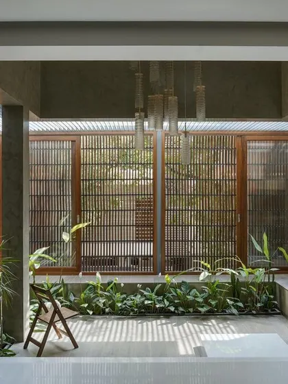A view from within the courtyard, looking through the slatted wooden screens that provide privacy while allowing light and air to filter through.