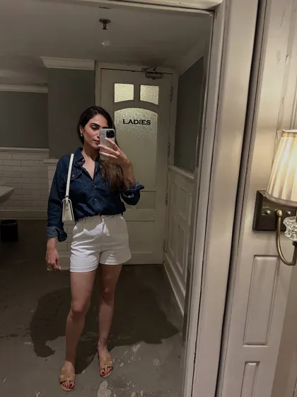 A casual mirror selfie in a denim shirt and white shorts. An easy, classic combo for a warm day.