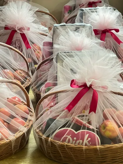 A close-up view of the wrapped 'Pink Lady' baskets, showing the detail of the tulle wrapping and ribbon.